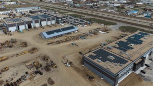 Distant drone shot of multiple buildings with solar arrays