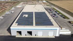 Distant drone shot of a building with solar arrays